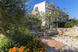 a house with a garden and flowers in front of it at Apartments Rado - close to the sea in Tkon