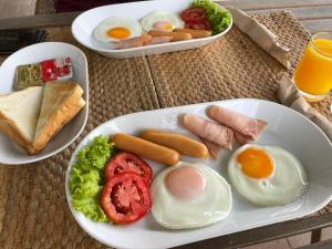 a plate of eggs and ham and bread with eggs and toast at บ้านฟ้าใส รีสอร์ท เกาะล้าน in Ko Larn