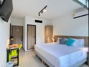 a bedroom with a large white bed and a yellow chair at HOTEL 9.5 SAN FERNANDO in Cali