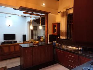 a kitchen with wooden cabinets and a counter top at Relax Villa In Koggala in Habaraduwa