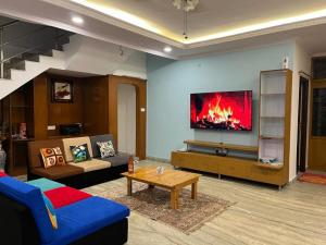 a living room with a couch and a fire in a tv at Bonjour Travellers Hostel in Hyderabad