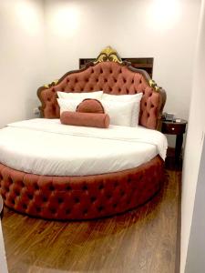 a bedroom with a large bed with a large headboard at Royal Hotel Sài Đồng - Long Biên in Hanoi