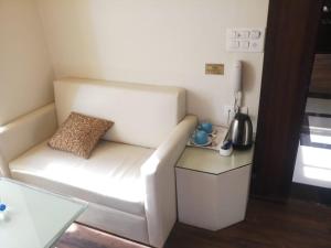 a living room with a white couch and a table at Krishna Palace in Jhālāwār