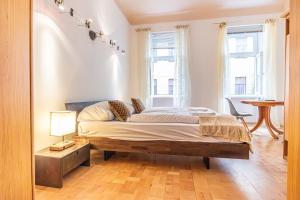ein Schlafzimmer mit einem Bett, einem Tisch und zwei Fenstern in der Unterkunft Peaceful Getaway 2BR Apartment with Shared Spaces in Wien