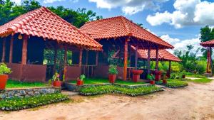 a house with two gazebos with plants at Ceylon Amigos Eco Resort in Sigiriya