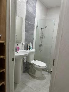 uma casa de banho com um WC, um chuveiro e um lavatório. em Apartamento Amueblado en Bonao em Bonao