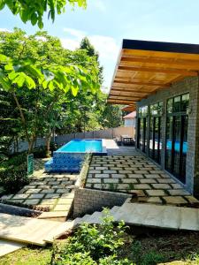 un patio trasero con piscina y una casa en Villa Ba Vi 6 Bedrooms & Pool DC Green Resort en Hanoi