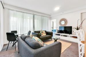 a living room with two couches and a television at Glam & Stylish Broadbeach 2BR Apartment in Gold Coast