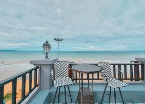 a balcony with a table and chairs and the beach at Seaside Jomtien Beach Pattaya in Jomtien Beach
