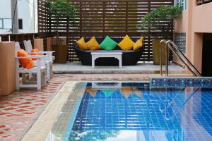 - une piscine avec un canapé et des oreillers dans l'établissement Seaside Jomtien Beach Pattaya, à Jomtien Beach