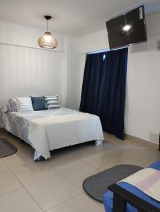 Monoambiente Tres Barrios في بوينس آيرس: غرفة نوم بسرير وستارة زرقاء