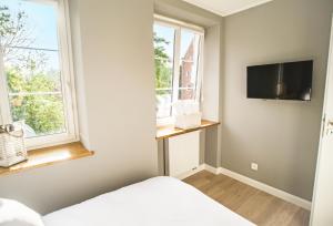 Apartament Targ Rybny - Gdańsk Old Town في غدانسك: غرفة نوم بسرير وتلفزيون على جدار