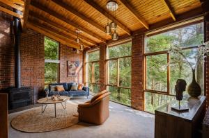 a living room with a couch and a table at Modern Seednest Treehouse, Forest & Mountain View in Sassafras