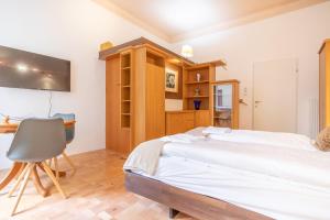 ein Schlafzimmer mit einem Bett, einem Schreibtisch und einem Stuhl in der Unterkunft Peaceful Getaway 2BR Apartment with Shared Spaces in Wien