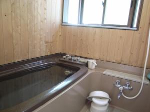 a bathroom with a tub with a toilet in it at Yama-gu - House / Vacation STAY 8426 in Inawashiro