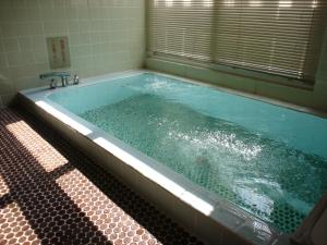 La salle de bains est pourvue d'une baignoire remplie d'eau. dans l'établissement Cottage All Resort Service / Vacation STAY 8435, à Inawashiro