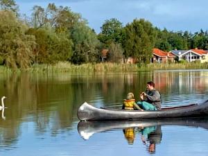 un hombre y una mujer sentados en una canoa en un lago en 6 person holiday home in Otterndorf, en Otterndorf