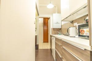 eine Küche mit Holzschränken und einer Arbeitsplatte in der Unterkunft Peaceful Getaway 2BR Apartment with Shared Spaces in Wien