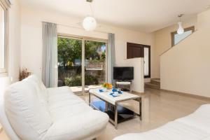 - un salon avec un canapé blanc et une table dans l'établissement Villa Panorama Tria, à Droushia