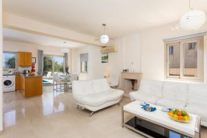 - un salon avec deux canapés blancs et une table dans l'établissement Villa Panorama Tria, à Droushia