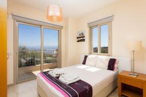 a bedroom with a bed and a large window at Villa Panorama Tria in Drousha +12 photos