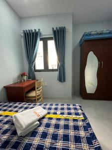 um quarto com uma cama, uma secretária e uma janela em penthouse BNB em Ho Chi Minh