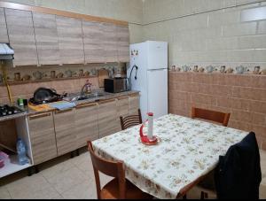 a kitchen with a table and a white refrigerator at Cité 200 logement lpp mimouni borj el Kiffan alger in Fort de lʼEau