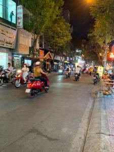 um grupo de pessoas a andar de moto numa rua à noite em penthouse BNB em Ho Chi Minh