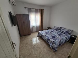 a bedroom with a bed with a blue comforter at Cité 200 logement lpp mimouni borj el Kiffan alger in Fort de lʼEau