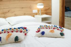 białe łóżko z dwoma poduszkami w obiekcie Lama Hostel w Iwano-Frankiwsku