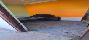une chambre vide avec un lit et un mur orange dans l'établissement SPOT ON The Elite, à Supaul