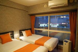 a hotel room with two beds and a window at SAPPORO HILLS in Sapporo