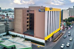 un edificio con un cartel al lado de una calle en City Express by Marriott CDMX Tlalpan, en Ciudad de México