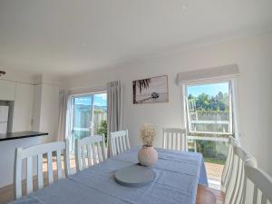 uma sala de jantar com uma mesa com um vaso sobre ela em Beautiful Brand New Four-Bed Home near Redwood em Rotorua