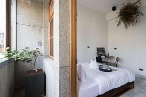 a bedroom with a bed in a room with a window at 軟寓 nńg inn in Tainan