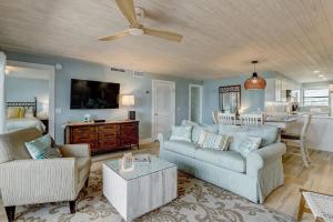 a living room with two couches and a tv at Amelia The Sea - 442 ASea in Fernandina Beach