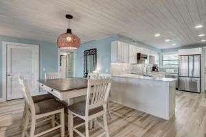 a kitchen with a table and chairs in a room at Amelia The Sea - 442 ASea in Fernandina Beach