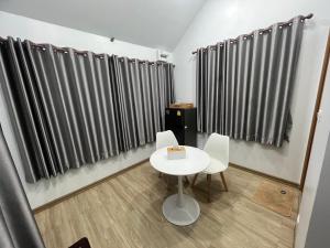 a small table and chairs in a room with striped curtains at ปางอ่ายแคมป์ปิ้ง in Ban Pang Ai