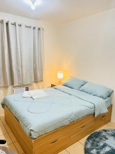 a bedroom with a large bed with blue sheets at New 8 Spatial Davao Smart Studio Unit Netflix Wi-Fi Amazon Voice Controlled Lights in Davao City