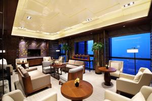 a lobby with couches and tables and a large window at HUALUXE Wuxi Taihu, an IHG Hotel in Wuxi