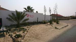 a street with a wall with a sign on it at Yield House and Cottages in Port Nolloth