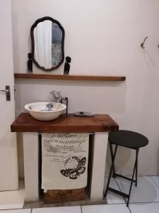 a bathroom with a sink and a mirror and a stool at Yield House and Cottages in Port Nolloth