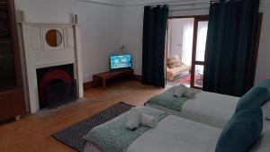 a living room with two beds and a fireplace at Yield House and Cottages in Port Nolloth