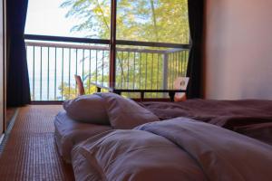a bed in a room with a large window at 123MUSIC(イズサンミュージック) in Atami