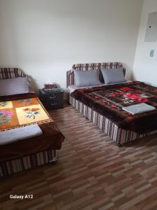 een slaapkamer met 2 bedden en een houten vloer bij Cloud housing jabal shams in Sa‘ab Banī Khamīs