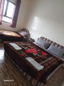 a bedroom with two beds and a window at Cloud housing jabal shams in Sa‘ab Banī Khamīs