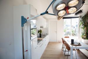 een keuken met witte kasten en een tafel met stoelen bij Tempor'area Apartment in Antwerpen
