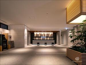 an empty lobby with a bench in a building at Daiwa Roynet Hotel Fukuyama Ekimae in Fukuyama
