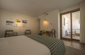 a bedroom with a large white bed and a window at Somewhere - Estoril Guesthouse in Estoril