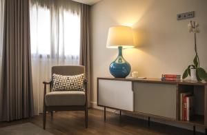 a room with a chair and a lamp on a desk at Somewhere - Estoril Guesthouse in Estoril